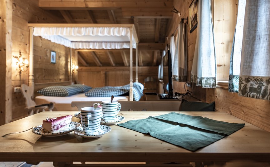 Gemütliches Holzinterieur mit gedecktem Tisch, Kuchen und Tassen