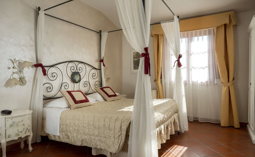 Gemütliches Schlafzimmer mit Himmelbett und gelben Vorhängen
