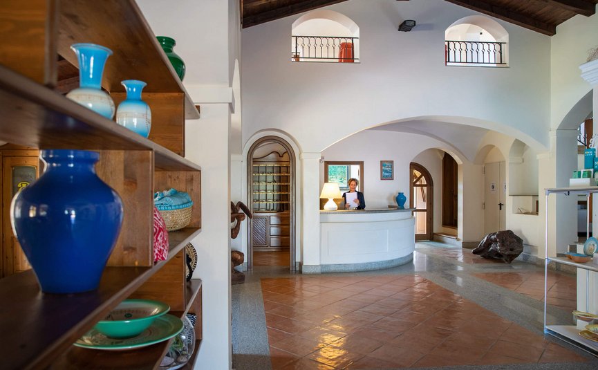 Hotel reception with staff, decorative vases, and bright interior