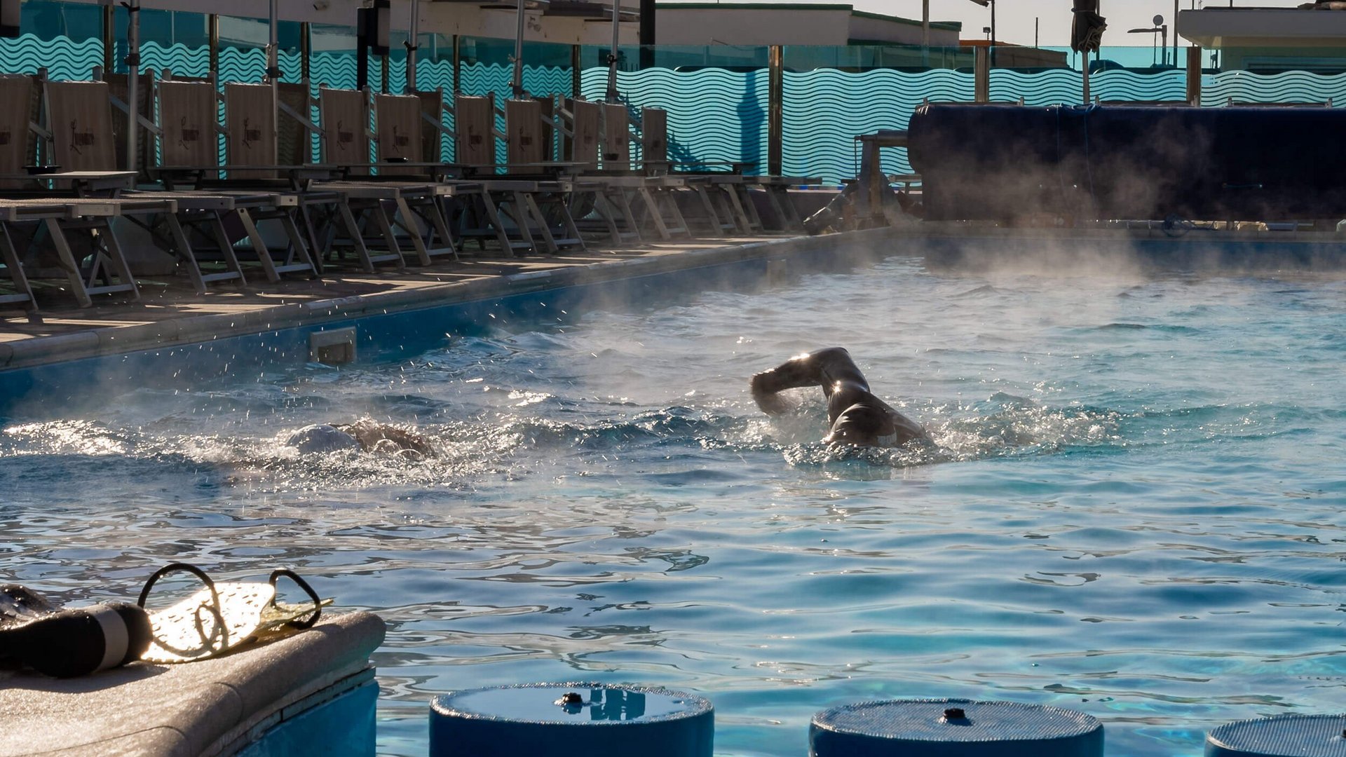 Due nuotatori in piscina riscaldata all'aperto al mattino presto