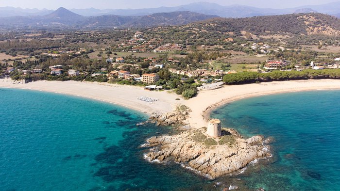 Aerial view of coast with ancient tower and clear blue sea