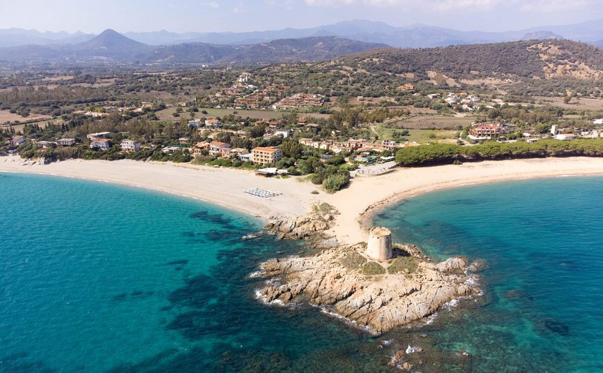 Aerial view of coast with ancient tower and clear blue sea