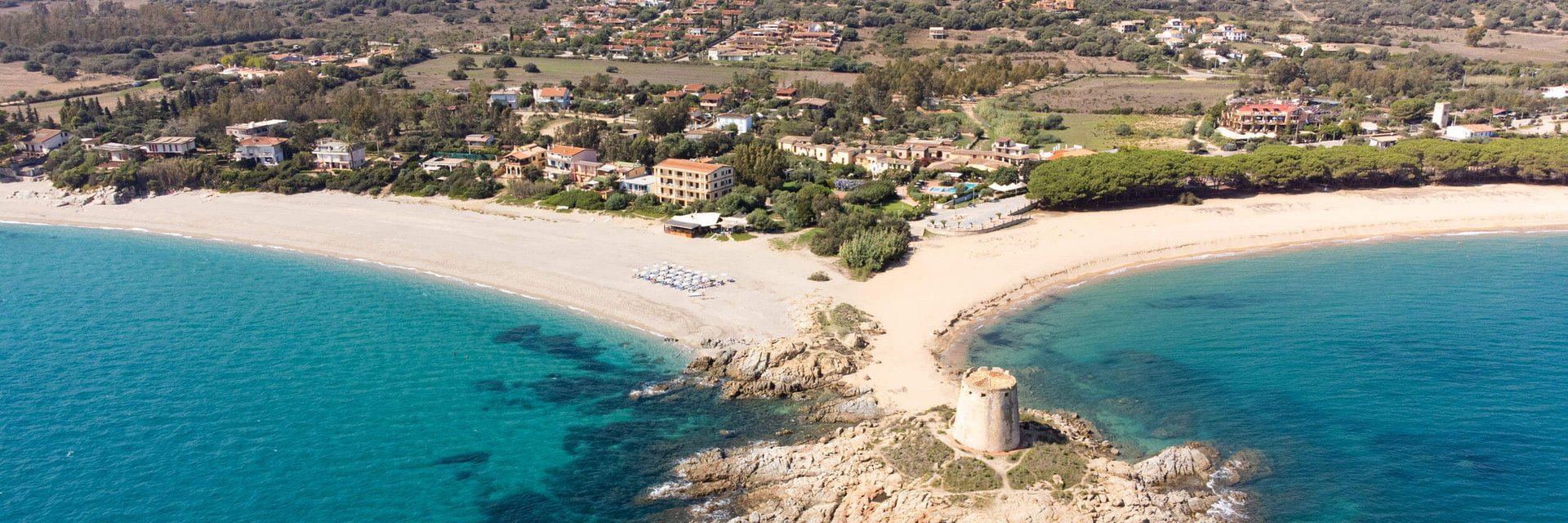 Veduta aerea della costa con torre antica e mare azzurro