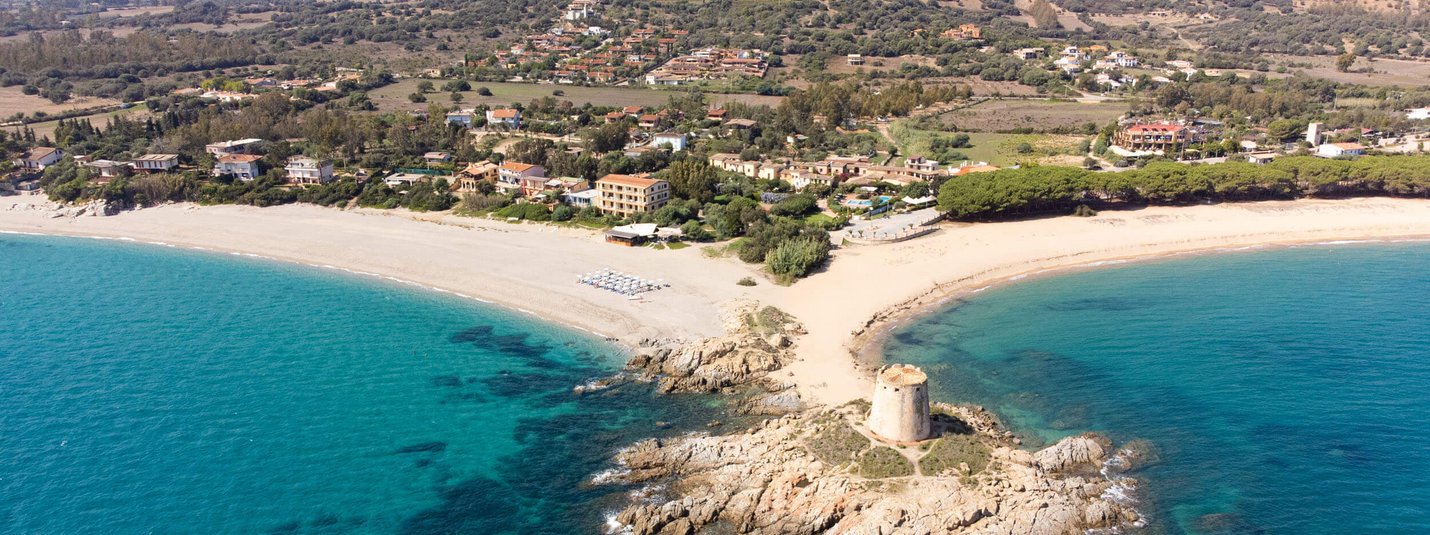 Veduta aerea della costa con torre antica e mare azzurro