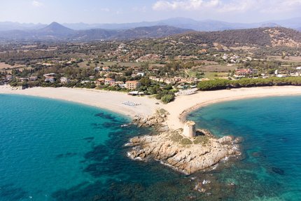 Aerial view of coast with ancient tower and clear blue sea