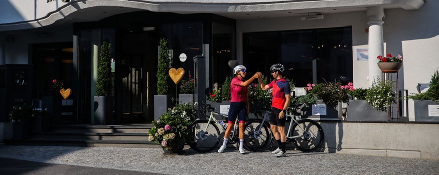 Alpen-Comfort-Hotel Central **** © Felix Saller Zwei Radfahrer klatschen vor dem Central Hotel ab