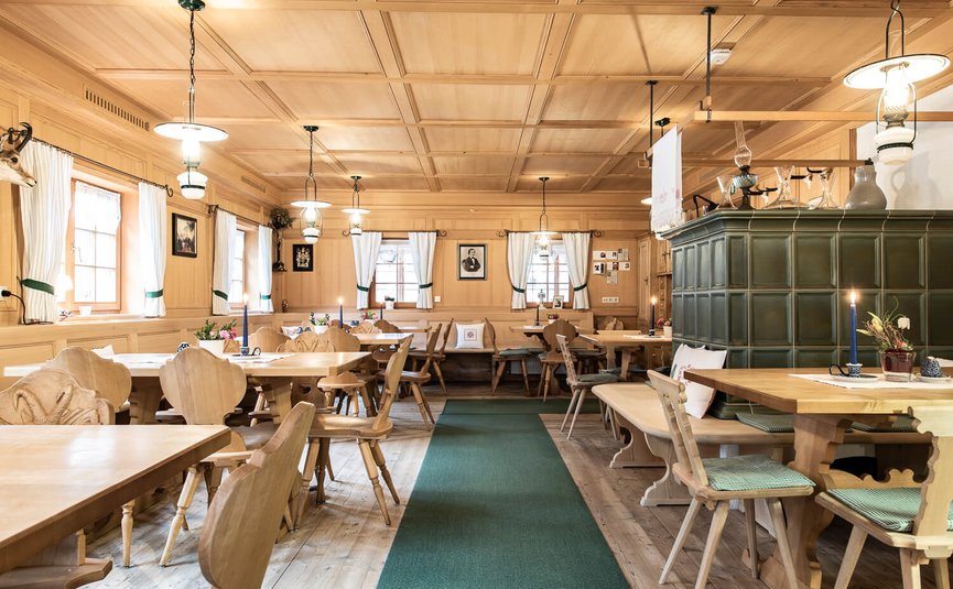 Traditionelles Holzrestaurant mit grünen Fliesenofen und Holzmöbeln