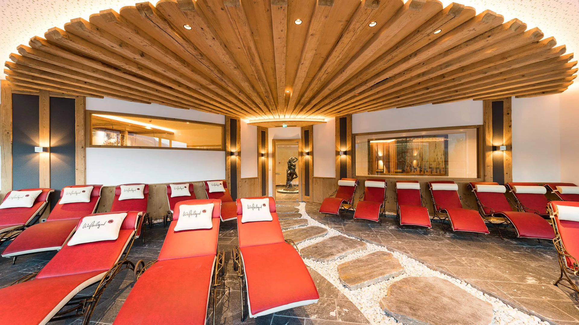 Sala relax con poltrone rosse e travi di legno al soffitto