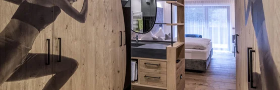 Camera da letto moderna con armadi in legno e biancheria da letto, illuminazione naturale