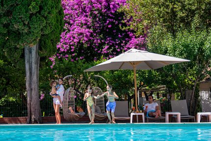 Family by the pool with kids ready to jump in