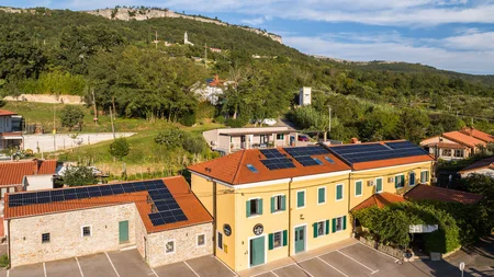 Breeze, Pulse oder Peak? 20 neue Traumrouten im Slowenischen Istrien © Jaka Ivancic Gebäude mit Solarzellen auf dem Dach vor bewaldetem Berg