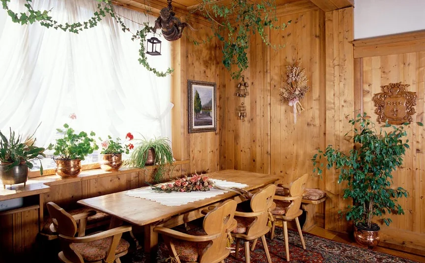 Cozy wooden dining table with chairs and plants in a traditional room