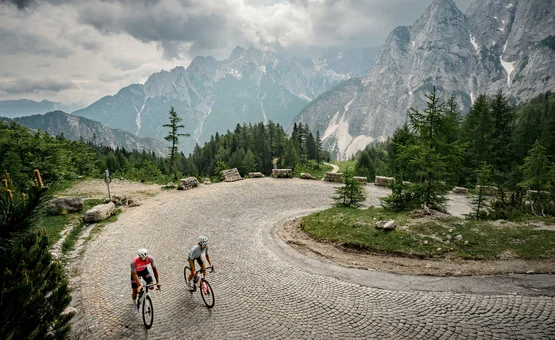 Vacanze in bici da corsa in Slovenia © Alain Rumpf Due ciclisti su una strada di montagna tortuosa con ripide pareti rocciose