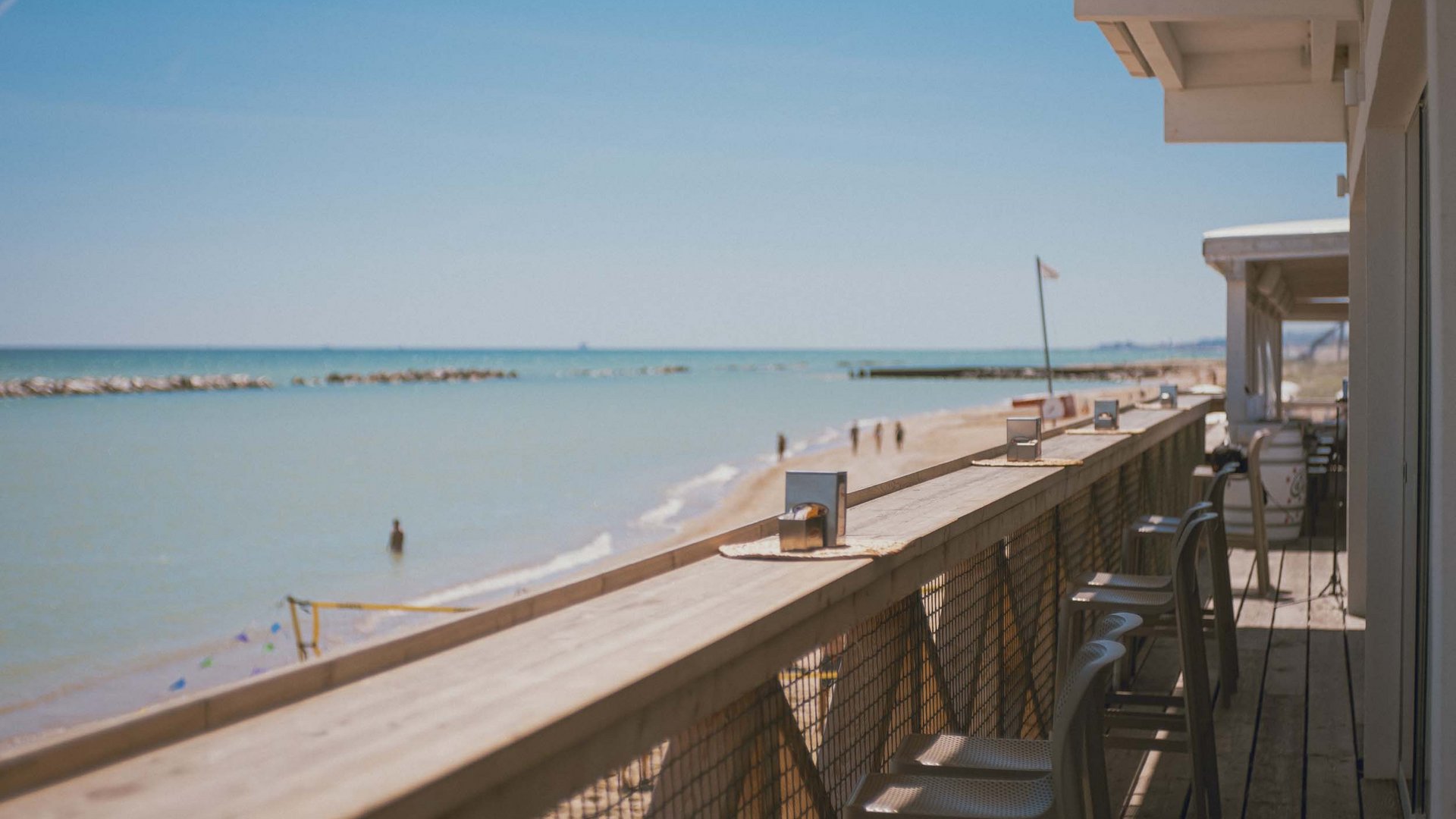 Blick von einer Strandbar auf den sonnigen Strand und das Meer