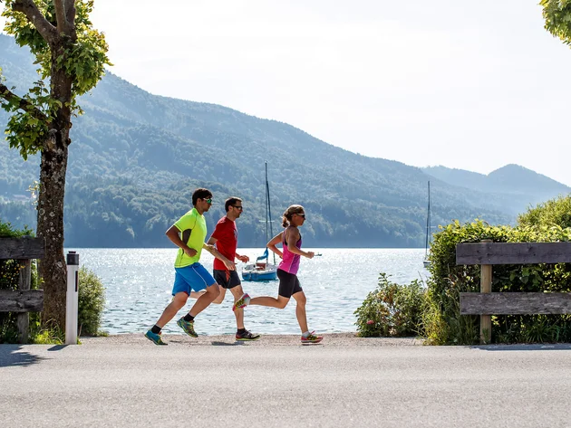 Ein Rennrad-Wochenende im SalzburgerLand – Salzkammergut © Erwin Haiden Drei Personen joggen am See mit Bergen im Hintergrund