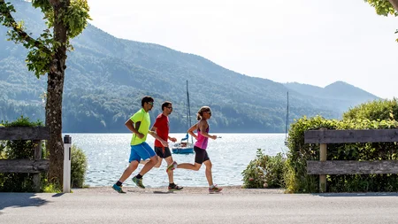Ein Rennrad-Wochenende im SalzburgerLand – Salzkammergut © Erwin Haiden Drei Personen joggen am See mit Bergen im Hintergrund