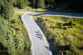 Three cyclists riding on a winding mountain road