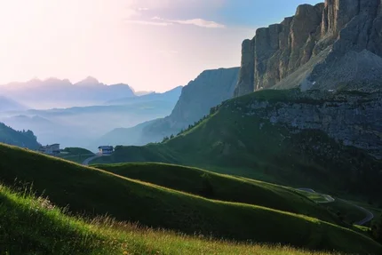 Grüne Hügel und Bergklippen bei Sonnenaufgang in den Alpen