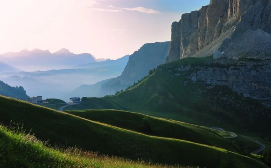 Tour delle Dolomiti © Hotel Teutschhaus Kurtinig Colline verdi e scogliere montuose all'alba nelle Alpi