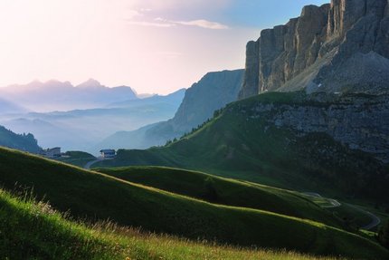 Groene heuvels en bergkliffen bij zonsopgang in de Alpen