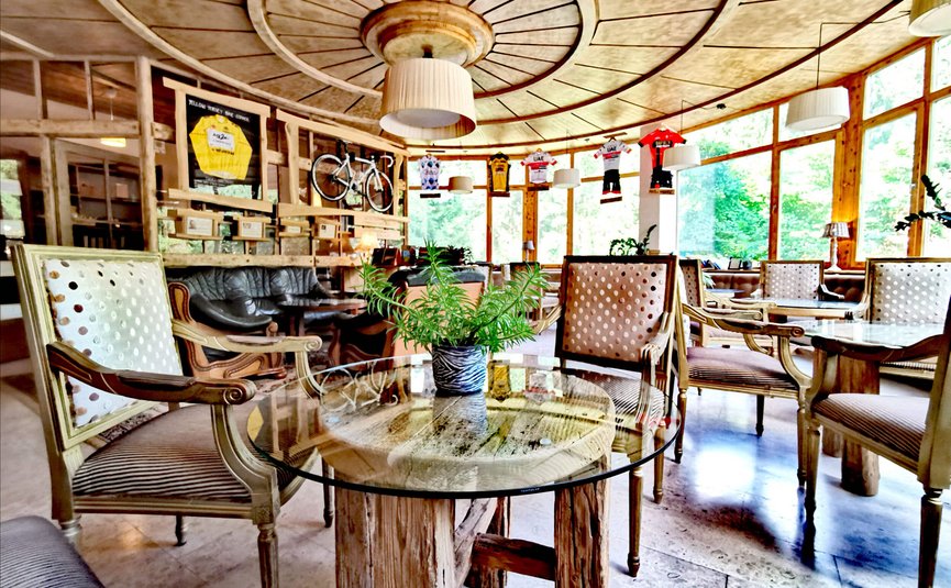 Sala da pranzo accogliente con soffitto in legno, sedie antiche e decorazioni biciclette