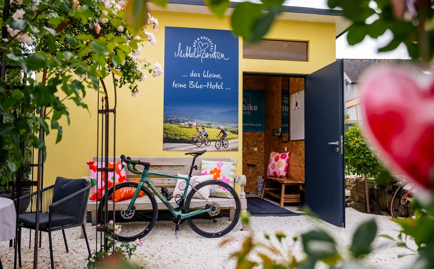 Bed&Breakfast Mittelkärnten © Michael Stabentheiner Bicicletta davanti a edificio giallo con panchina e cuscini colorati in giardino