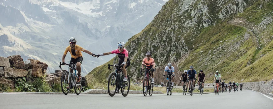 Ciclisti in montagna, due si tengono per mano