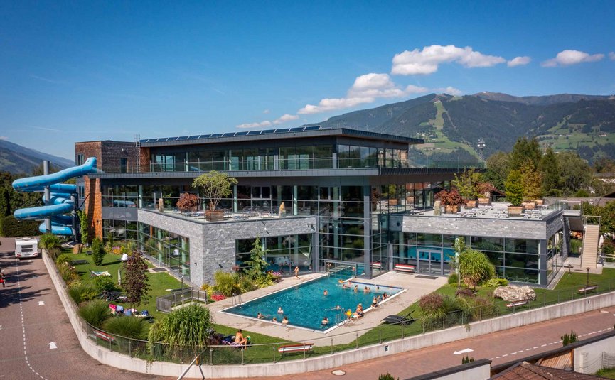 Modern swimming pool with outdoor pool and water slide by mountains