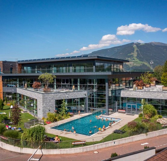 Modern swimming pool with outdoor pool and water slide by mountains