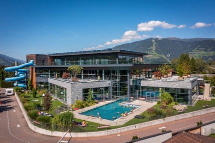 Piscina moderna con piscina esterna e scivolo d'acqua vicino alle montagne