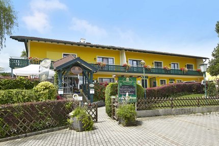 Yellow country hotel with balcony and garden on a sunny day