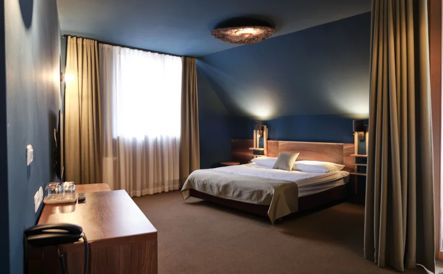 Camera d'hotel accogliente con pareti blu e letto matrimoniale