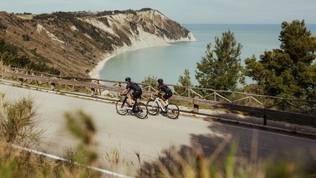 Zwei Radfahrer fahren an der Küste mit Blick auf das Meer und die Klippen vorbei