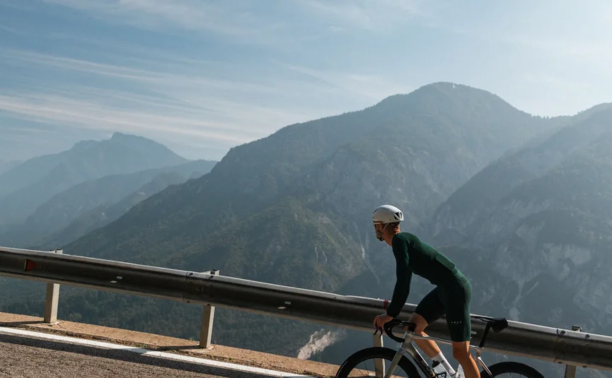 Cristallo Sport & Wellness Hotel **** © marc.moves x velysiped Radfahrer fährt bergauf auf asphaltierter Straße mit Bergkulisse im Hintergrund