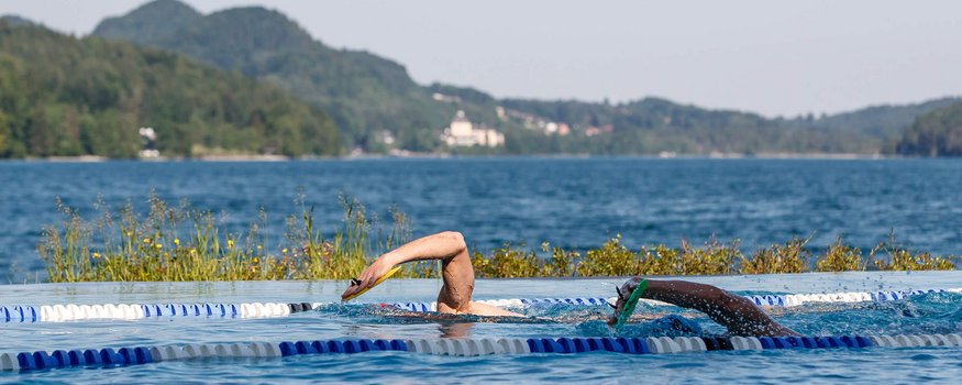 Triathlon Hotels: Deine Base für Training & Erholung © Erwin Haiden Zwei Schwimmer schwimmen in Außenbecken mit Berglandschaft im Hintergrund