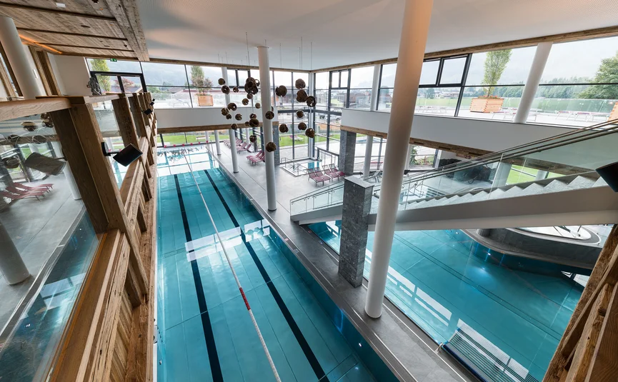 Interieur van een modern zwembad met grote banen en ligstoelen