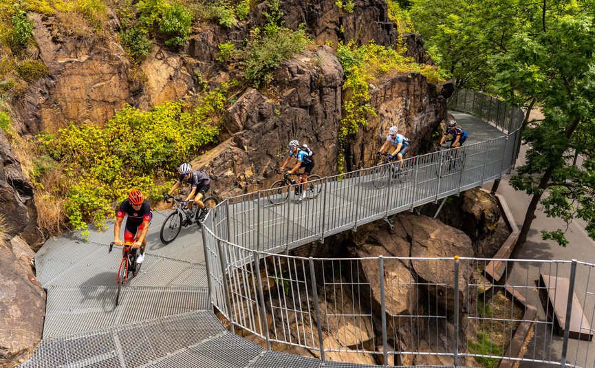 Ciclisti su un ponte metallico in un terreno roccioso