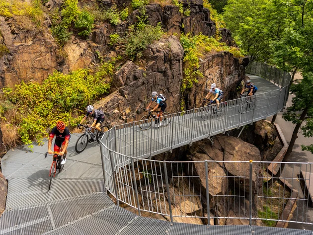 Fietsers rijden over een metalen brug door rotsachtig terrein