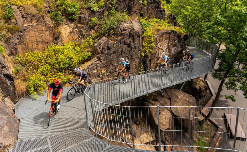 Radfahrer fahren auf einer Metallbrücke durch felsiges Gelände