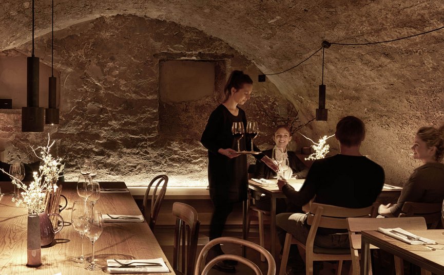Cozy restaurant with waitress serving wine to guests
