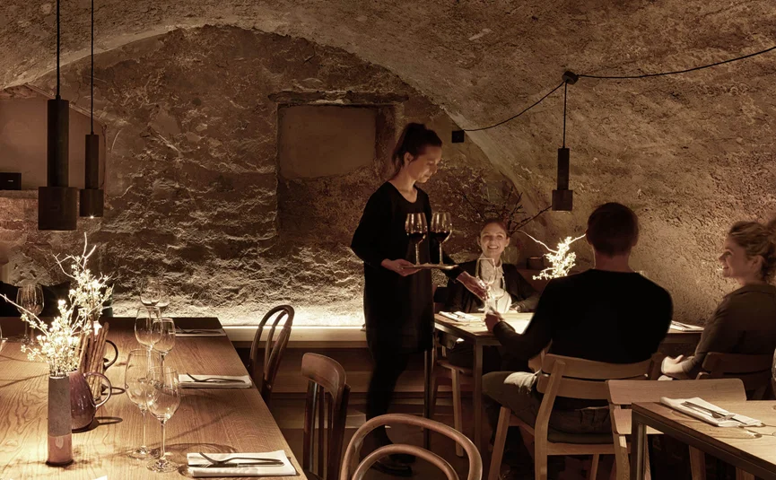 Gemütliches Restaurant mit Kellnerin, die Wein serviert