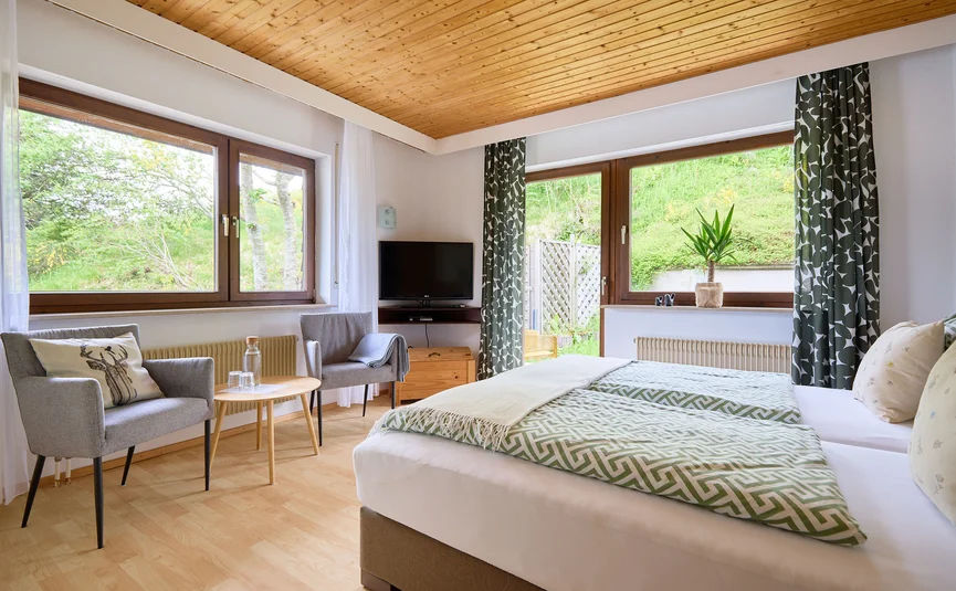 Lichte hotelkamer met twee bedden en twee fauteuils