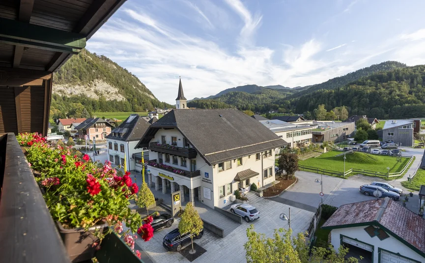 Vista di un piccolo villaggio con chiesa e montagne sotto un cielo sereno