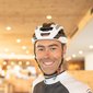 Ciclista sorridente con casco all'interno di un hotel