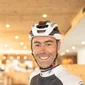 Daniele Acler © Daimp Gestioni Srl Lächelnder Radfahrer mit Helm im Hotelinnenbereich