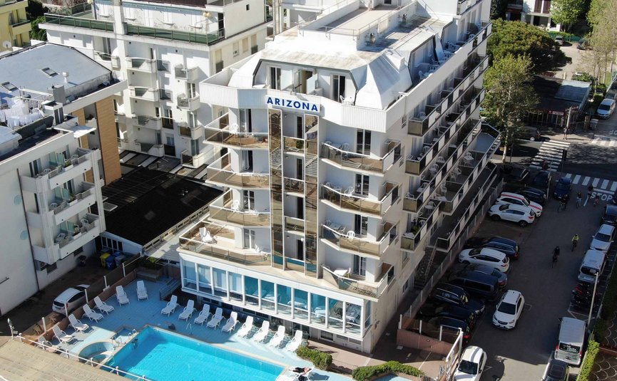 Hotel con piscina all'aperto e sdraio in ambiente urbano soleggiato
