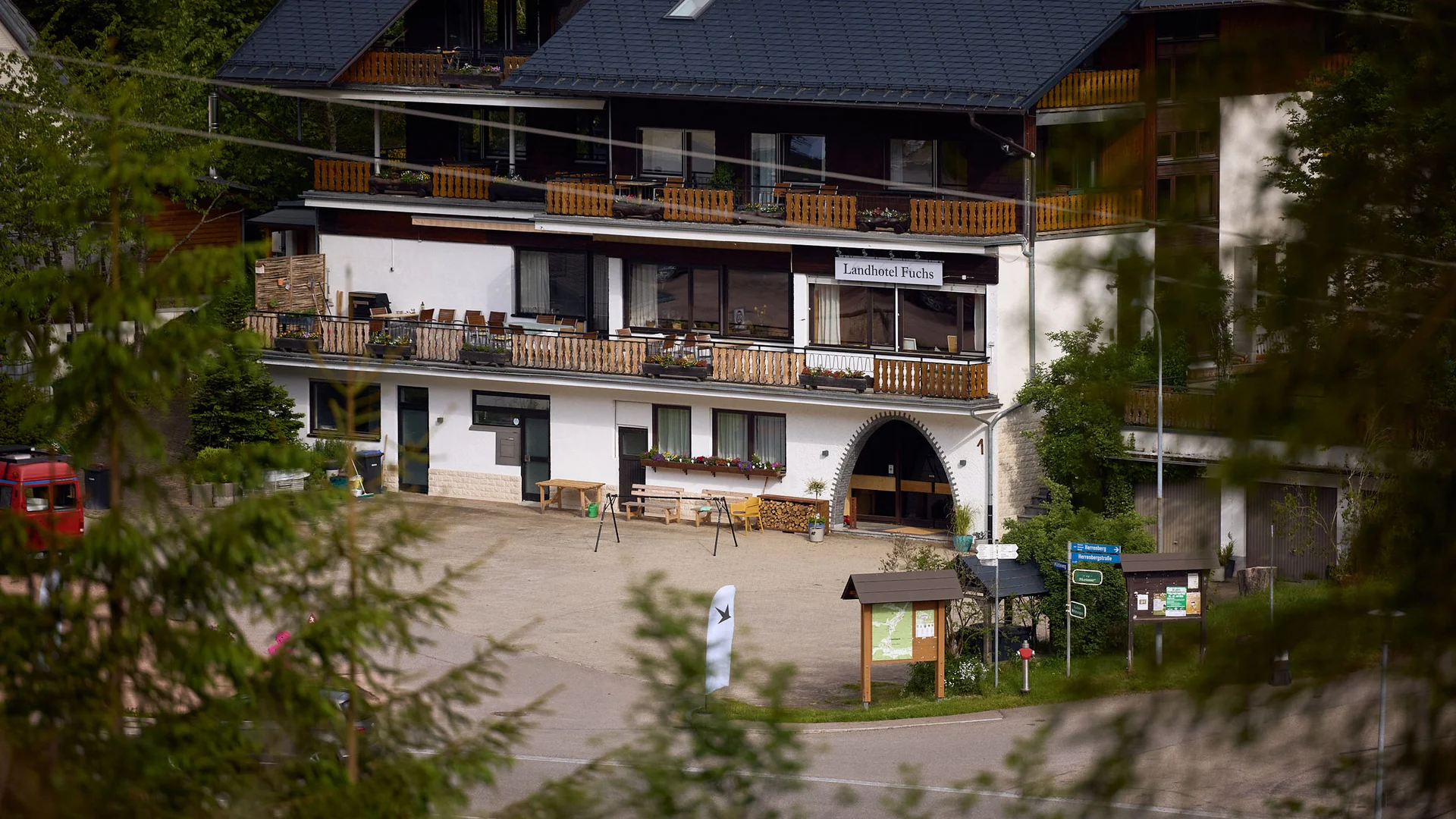 Landhotel Fuchs in einem Waldgebiet mit Schildern und Sitzbereich