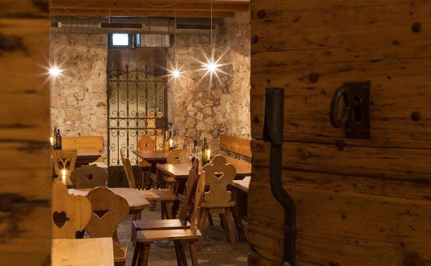 Gemütliches Restaurant mit Holzstühlen und rustikaler Steinmauer