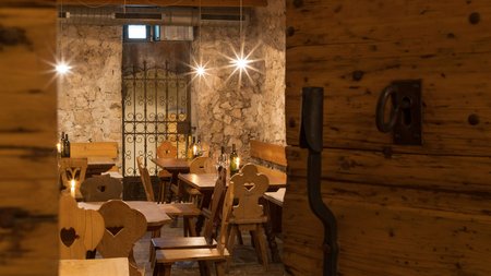 Gemütliches Restaurant mit Holzstühlen und rustikaler Steinmauer