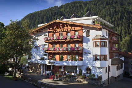 Hotel met bloemversierde balkons in bergachtige omgeving